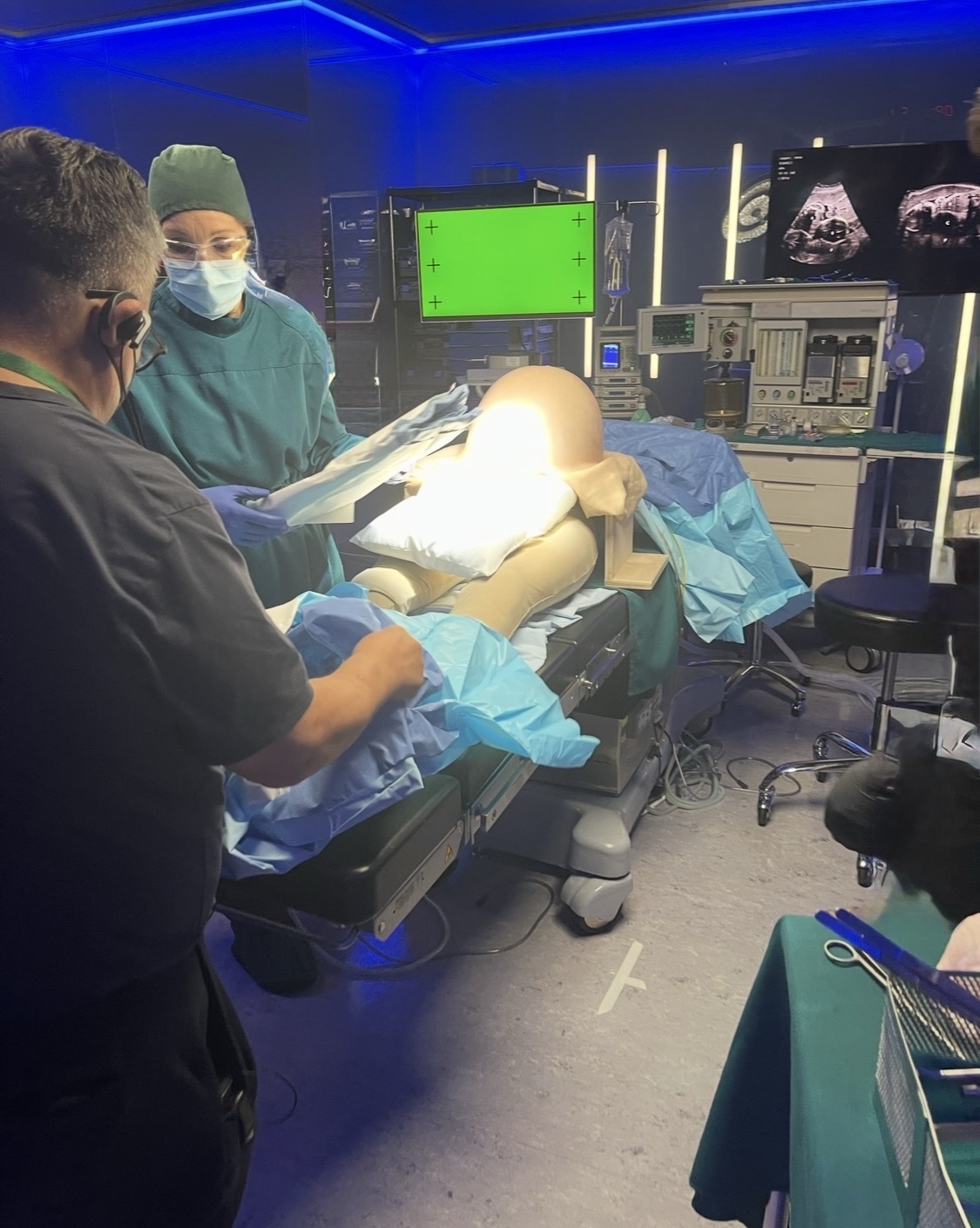 A medical procedure scene being prepared with a mannequin, monitors and production equipment.